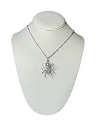a silver spider necklace on a mannequin