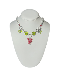 a necklace with a flower and leaves on a mannequin