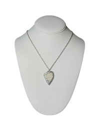 a necklace with a heart shaped pendant on a mannequin
